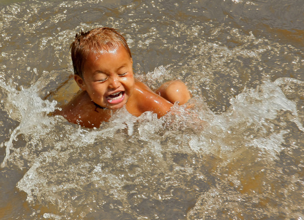 Little Boy Splashing in Pond